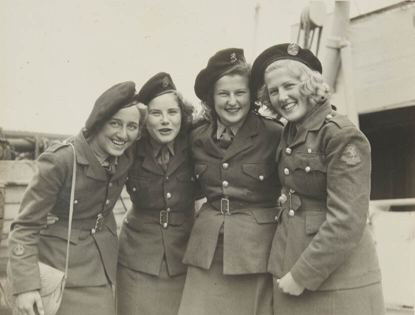 Zwart-witfoto van 4 lachende vrouwen in militair uniform.
