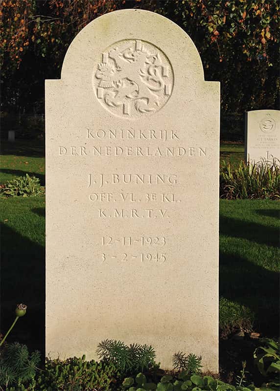 Kleurenfoto. Een grafsteen met een ronde bovenkant. in de ronding is een cirkel aangebracht met het reliëf van de Nederlandse leeuw: zwaard in één poot, pijlen in de ander, blokjes eromheen. Onder de reliëf staat Koninkrijk der Nederlanden en daaronder de gegevens van de overledene: J.J. Buning, off. Vl. 3e kl., K.M.R.T.V., gevolgd door de geboortedatum 12-11-1923 en overlijdensdatum 3-2-1945