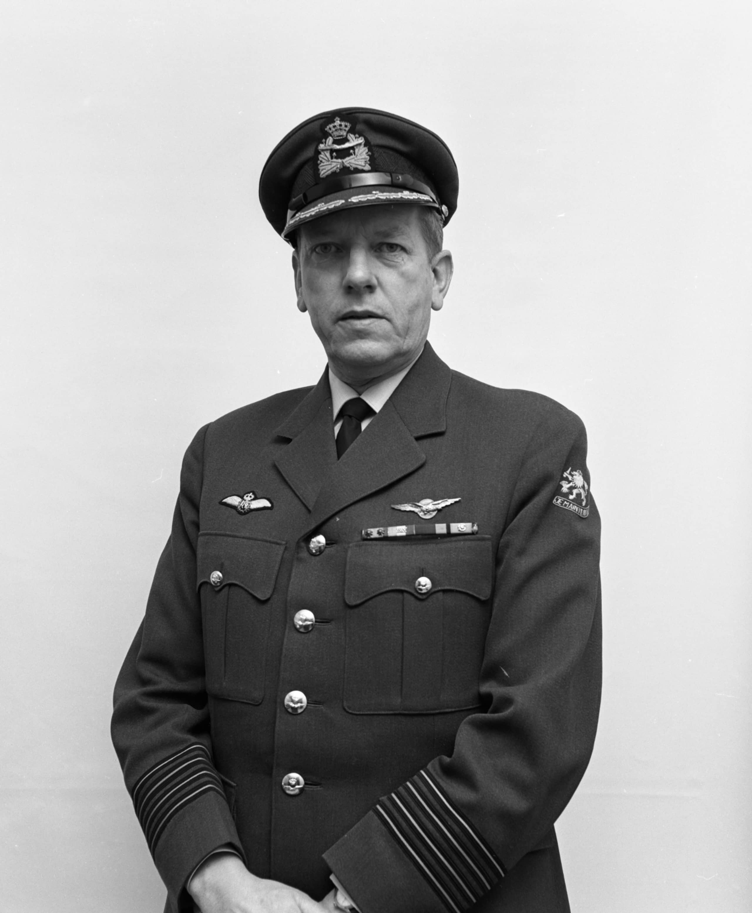 Zwart-witfoto. Man in uniform kijkt recht de camera in.