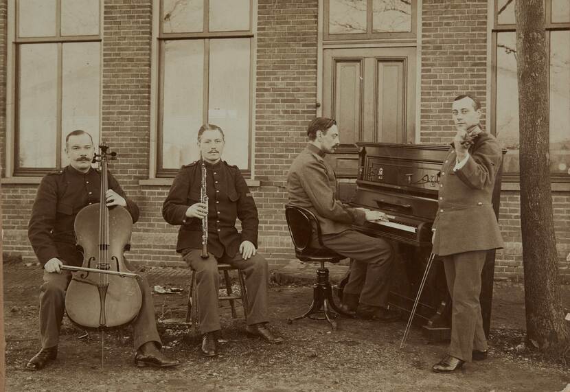 Zwart-wit foto waarop het militair ensemlbe poseert met hun instrumenten.