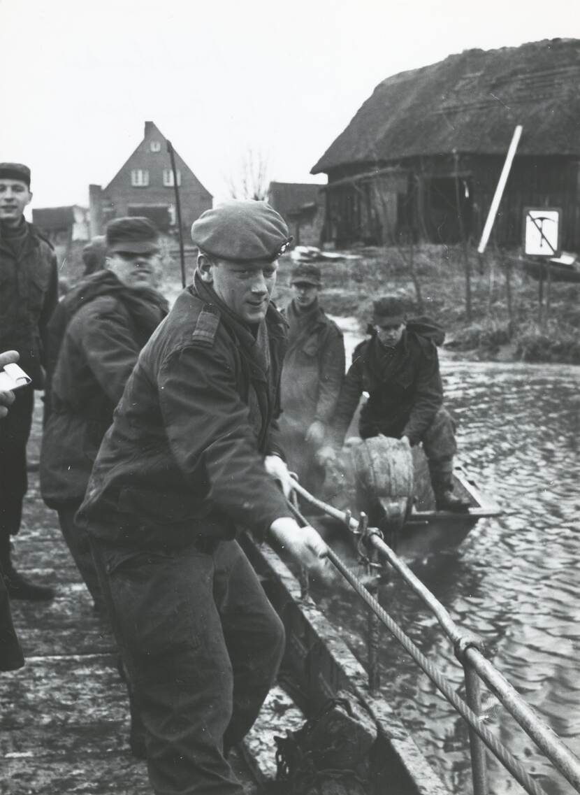Zwart-witfoto, militairen zijn bezig met een trekpont water over te steken.