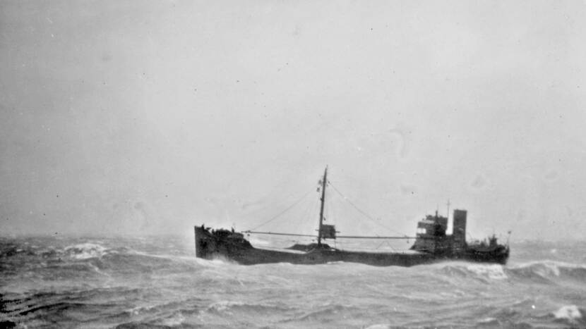 Zwart-wit foto genomen vanaf het marineschip Jacob van Heemskerck (niet te zien op de foto). In de verte is in het water een koopvaardijschip te zien.
