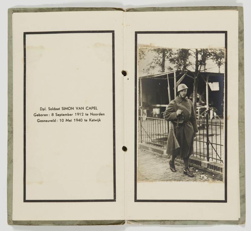 Zwart-witfoto. Twee pagina’s uit een boek, links persoonsgegevens met geboortedatum, geboorteplaats, overlijdensdatum en overlijdensplaats. Rechts een foto van een lopende militair, hij kijkt in de camera en draagt een helm en een geweer over zijn rechterschouder, hij loopt langs een tuinhek, in de achtergrond een bestraatte voortuin en een schuur.
