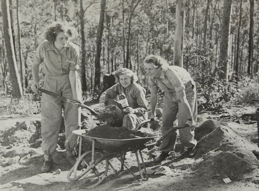 Zwart-witfoto van drie vrouwen in overals die buiten aan het werk zijn.