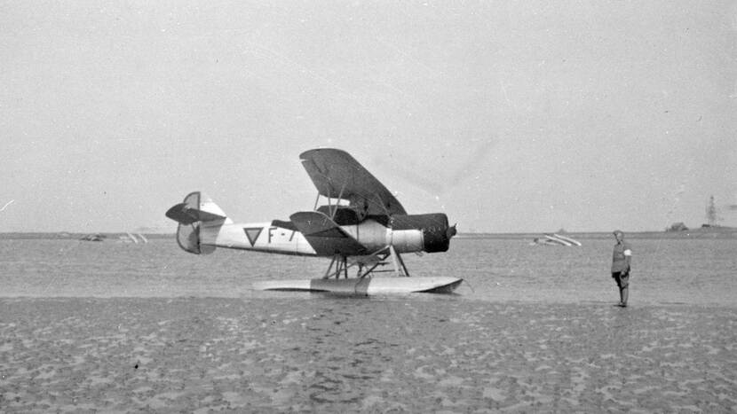 Een beschadigde Fokker C.14W ligt na de Meidagen van 1940 hulpeloos op een strand. Op de achtergrond liggen twee toestellen op de kop in het water.