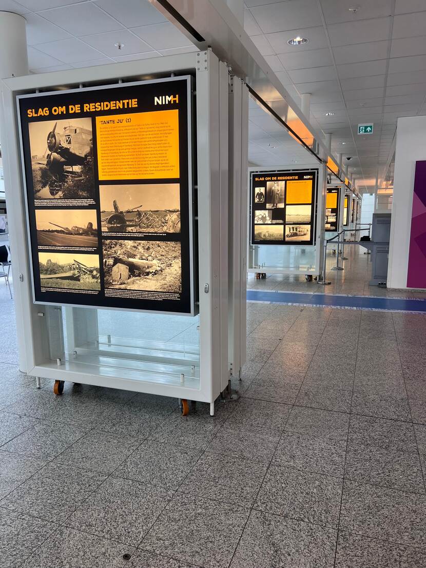 Schuin zicht op een aantal panelen van de tentoonstelling. Op het voorste paneel is beeld en tekst over 'Tante Ju' te zien.